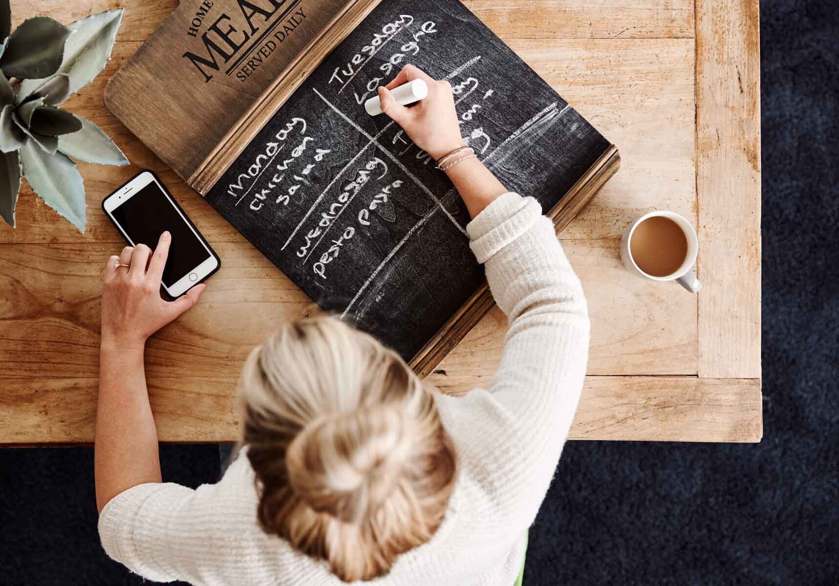 overhead-shot-looking-down-on-woman-at-home-writin-ED2ZMNP